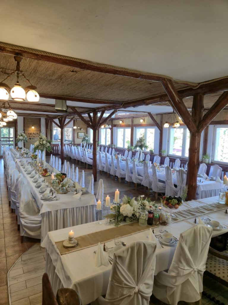 Elegancko nakryta sala weselna ze świecami i kwiatami