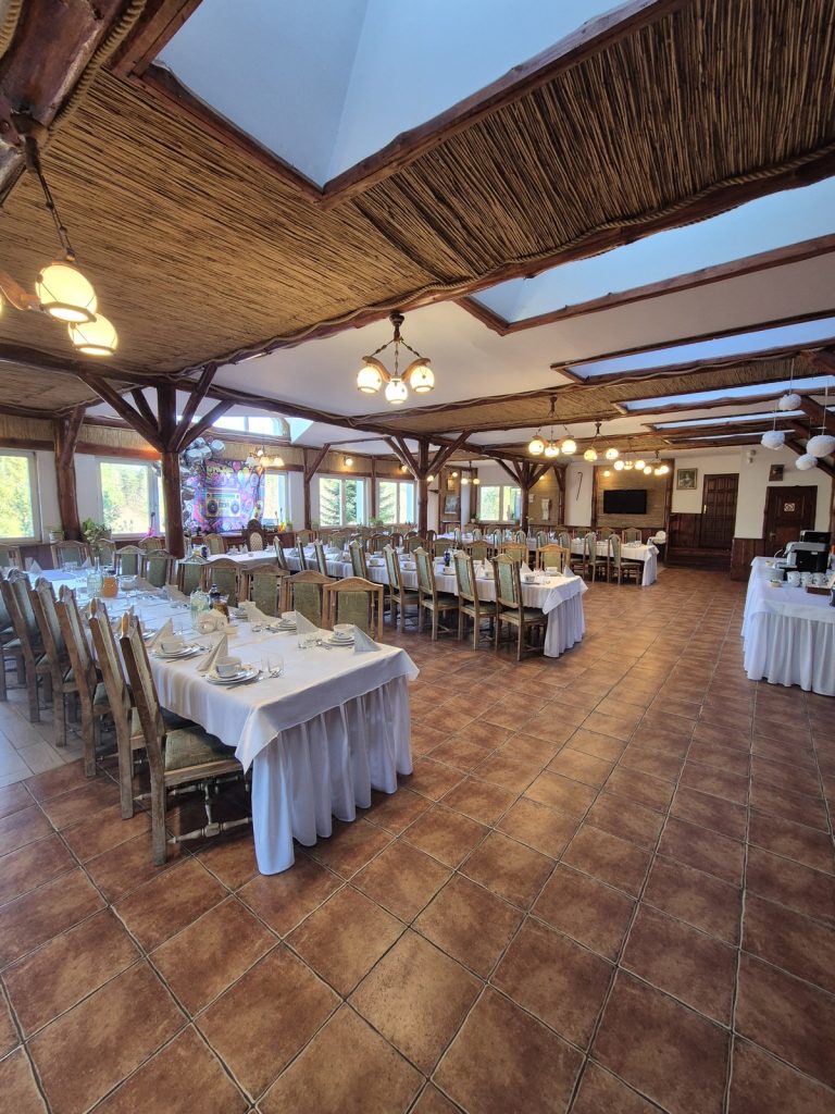 Przestronna sala z nakrytymi stołami